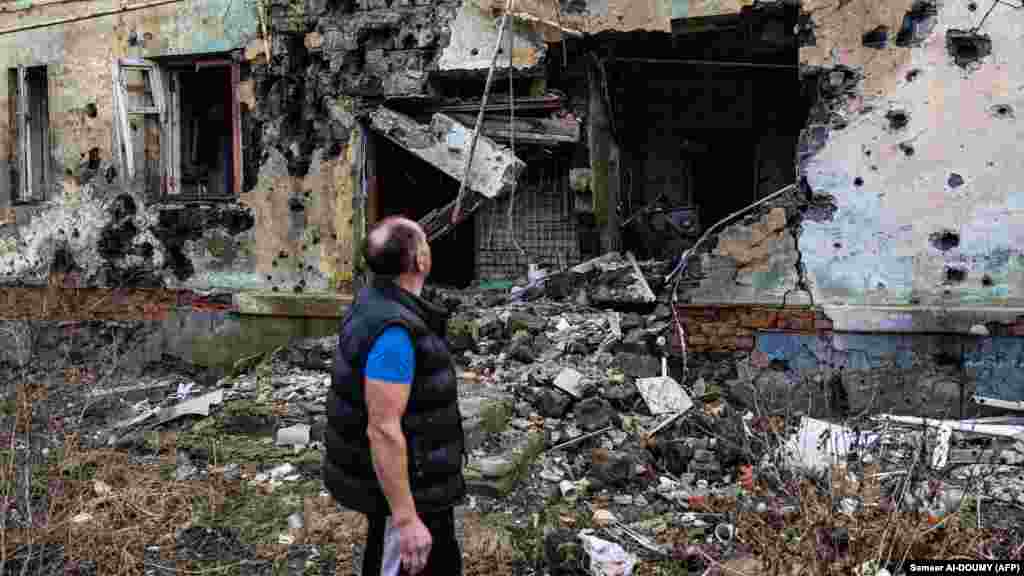 Andrei Pleșan, 60 de ani, evaluează distrugerile cauzate pivniței lui&nbsp;de la Izium, estul Ucrainei. Pivnița de 70 de metri pătrați, în care continuă să trăiască, a fost folosită ca adăpost și în al Doilea Război Mondial. 2 ianuarie 2022.