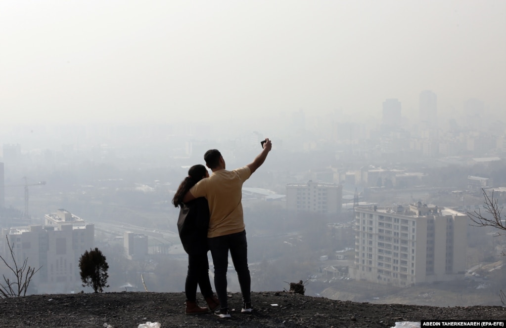Një çift iranian shihet duke bërë fotografi mbi Teheran.