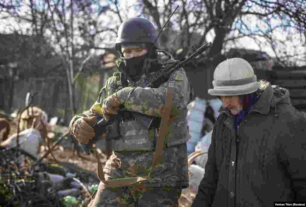 Украинский военный сопровождает местную жительницу, 7 декабря 2022 года Серьезные проблемы для жителей Бахмута&nbsp;создают не только обстрелы, но и зимние морозы в отсутствие электричества и воды