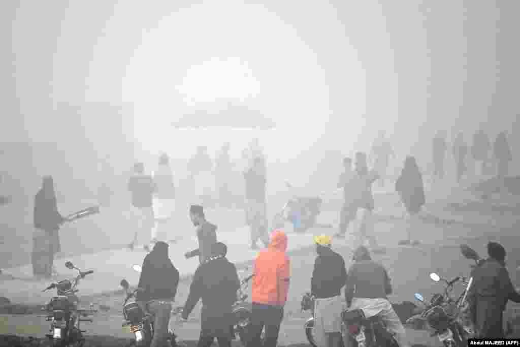 Youths play cricket amid foggy conditions in Peshawar in northern Pakistan.