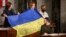 Ukrainian President Volodymyr Zelenskiy gives a Ukrainian national flag to U.S. House Speaker Nancy Pelosi and Vice President Kamala Harris (left) during his address the U.S. Congress at the U.S. Capitol in Washington, D.C. on December 21. 