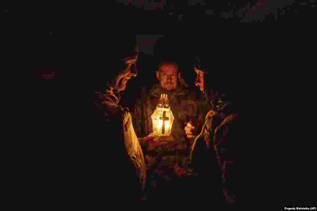 Ukrainian soldiers pray as they receive a Bethlehem Light of Peace from a comrade during Christmas holidays at their position near Kharkiv on December 26.