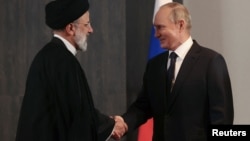 Președintele rus Vladimir Putin dând mâna cu președintele iranian Ebrahim Raisi, în timpul unei întâlniri la summitul Organizației de Cooperare de la Shanghai, Samarkand, Uzbekistan, 15 septembrie 2022