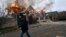 A local resident runs past a burning house hit by Russian shelling in Kherson, Ukraine, on January 6. 