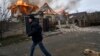Un localnic fugind lângă o casă bombardată de ruși la Herson, în Ucraina, 6 ianuarie 2023