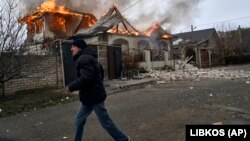 Un localnic fugind lângă o casă bombardată de ruși la Herson, în Ucraina, 6 ianuarie 2023