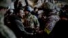 Ukrainian President Volodymyr Zelenskiy (left) hands out a state award to one of his country's soldiers who is defending the eastern frontline city of Bakhmut on December 20. 