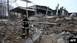 Украинский спасатель среди обломков разрушенного в результате российских ударов здания. Харьков, 16 декабря 2022 года