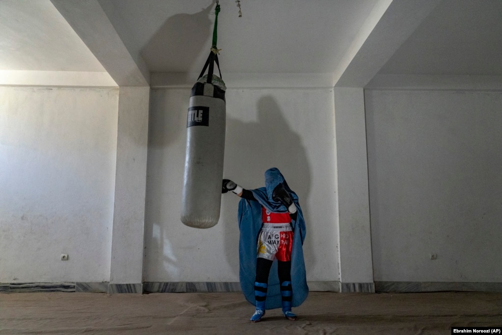 Portreti i një gruaje afgane që praktikon boksin tajlandez, apo muai tai, në Kabul. Një grua tjetër, Sarina, 20-vjeçare, luftëtare e arteve të përziera luftarake, ka kujtuar se si, në gushtin e vitit 2021, ka garuar në një turne lokal grash në një sallë sportesh në Kabul. Fjalët ishin përhapur nga audienca dhe pjesëmarrëset se luftëtarët talibanë ishin afruar në periferinë e qytetit. Të gjitha gratë dhe vajzat kishin ikur nga salla. Kjo ka qenë gara e fundit në të cilën ajo mori pjesë.