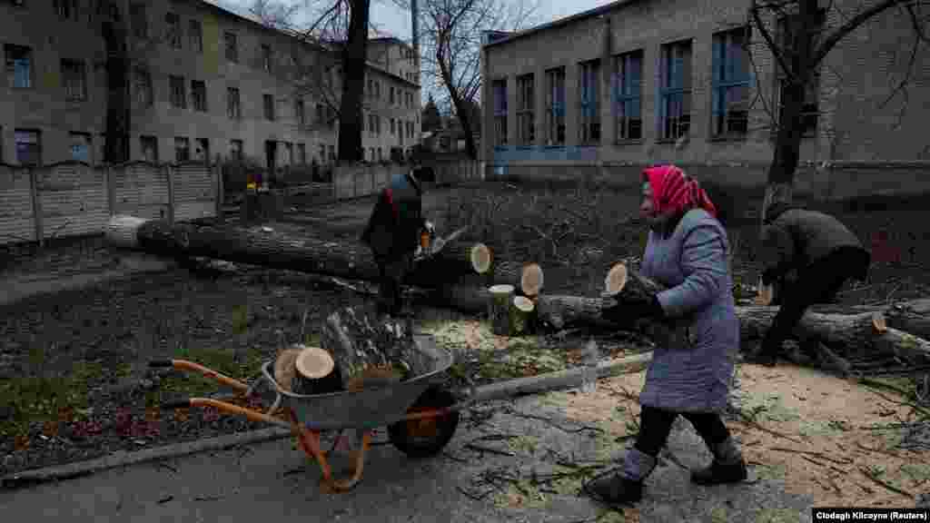 A helyiek kivágják a város fáit, hogy gázellátás híján fűteni tudjanak. A fotón a 73 éves Pilaheja Mihajlovna a szomszédaival egy talicskába rakja a felaprított fát