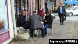 Мужчины играют в карты у магазина на улице Пушкина