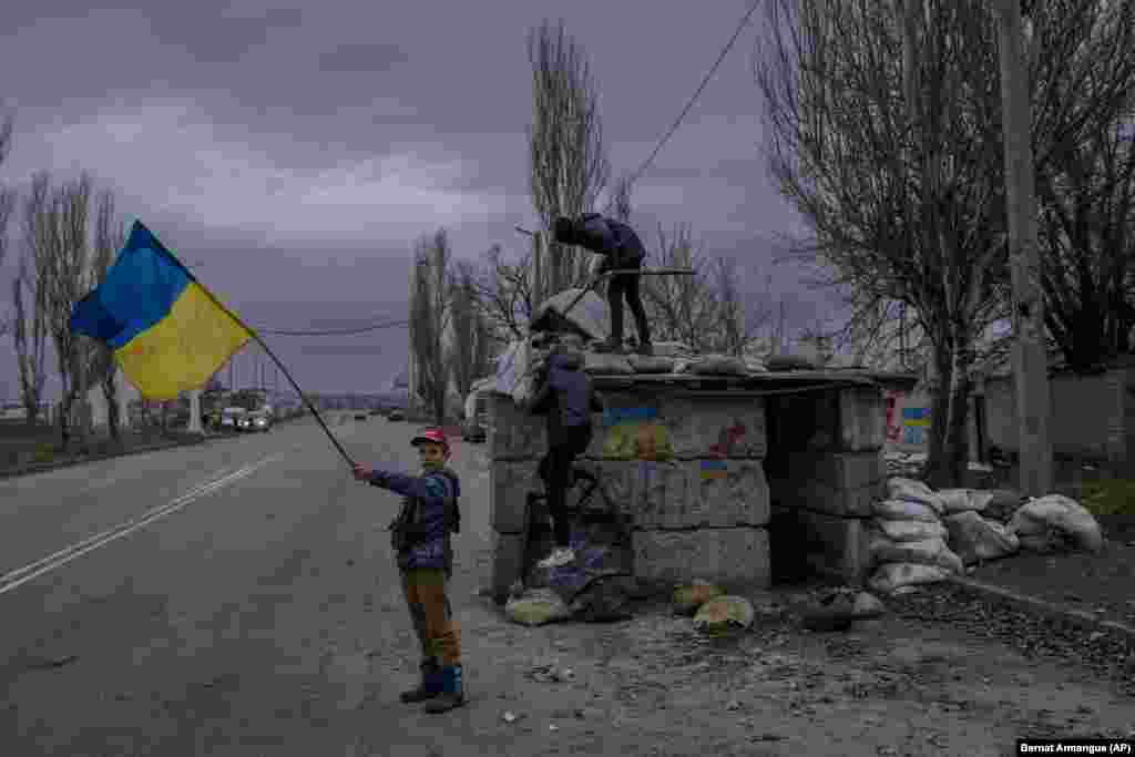 Ukrainian children play at an abandoned checkpoint in Kherson.