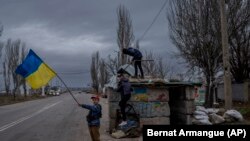 Ukrán gyerekek játszanak egy elhagyott ellenőrző ponton Herszonban 2022. november 23-án