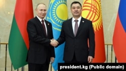 Russian President Vladimir Putin (left) shakes hands with Kyrgyz counterpart Sadyr Japarov at a meeting of the Supreme Eurasian Economic Council in Bishkek on December 9.