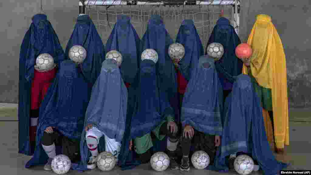 Женски фудбалски тим позира за портет, во Кабул.&nbsp;Жените и девојките мора да го кријат својот идентитет со бурки &ndash; наметки и качулки кои целосно им ги покриваат лицата, оставајќи им само мрежа низ која може да се гледа &ndash; додека се соочуваат со заплашување, закани и во некои случаи, тепање од членовите на семејството затоа што спортуваат. &nbsp;