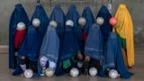 An Afghan women&#39;s soccer team poses for a portrait in Kabul. Women and girls must conceal their identities with burqas -- the all-encompassing robes and hood that completely cover their faces, leaving only a mesh to see through -- as they face intimidation, threats, and, in some cases, beatings from their own family members for playing sports.