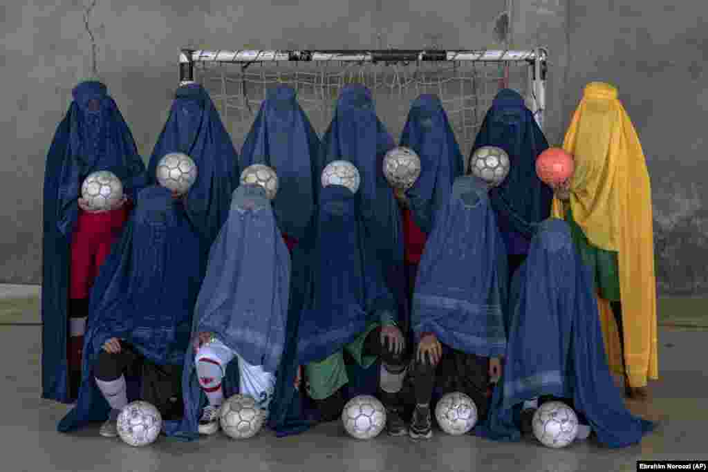 An Afghan women&#39;s soccer team poses for a portrait in Kabul. Women and girls must conceal their identities with burqas -- the all-encompassing robes and hood that completely cover their faces, leaving only a mesh to see through -- as they face intimidation, threats, and, in some cases, beatings from their own family members for playing sports.