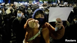 Манифестанты с белыми листами бумаги в руках, символом протеста. Пекин, вечер 27 ноября 2022 года