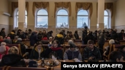 People gather at the railway station in Kherson as they charge their electronic devices and wait to board an evacuation train earlier this week. 