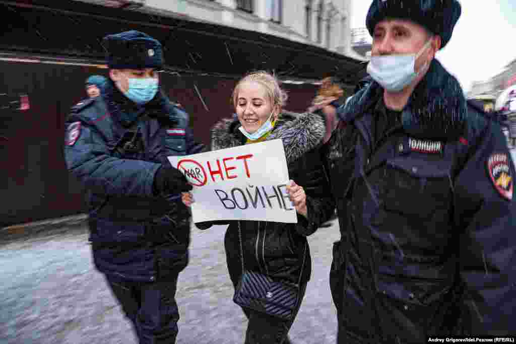 27 февраля, полицейские ведут в автозак одну из участниц антивоенного протеста. Всего в тот день речь шла о нескольких десятках задержанных.