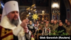 Ukrajinski vojnici i građani na Misi polnoćki u katedrali sv. Mihovila, Kijev, 6. januar 2023.