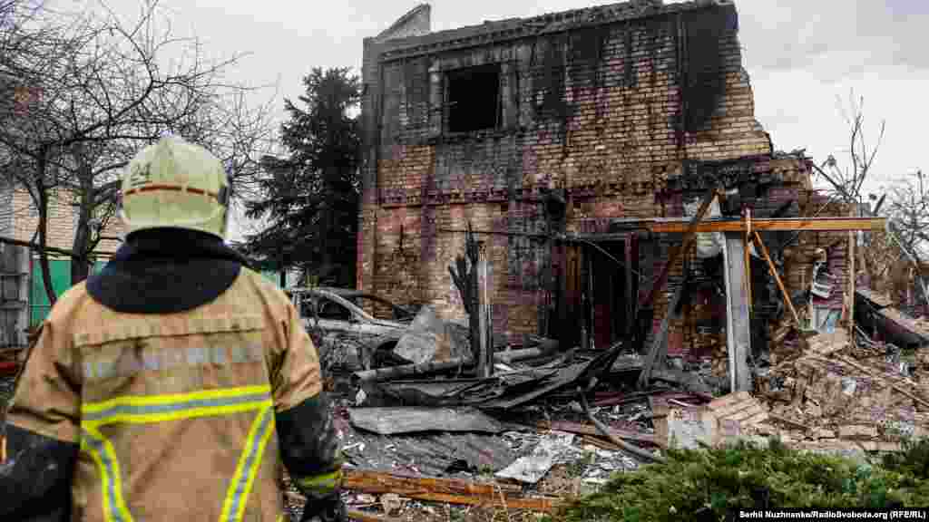Oroszország légitámadást indított az ukrán főváros ellen (is) csütörtökön, amely a jelek szerint pénteken is folytatódik. A fotón egy tűzoltó áll egy csaknem teljesen kiégett családi ház előtt Kijev Oszokorka kerületében december 29-én