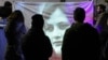 Protesters looks at an image of Mahsa Amini, whose death in police custody in September has sparked months of protests, during a candlelight vigil in front of Iranian Embassy in Rome.
