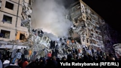 Rescue workers search through the rubble of an apartment building in Dnipro, Ukraine, following a devastating Russian missile strike on January 14. (Yulia Ratsybarska, RFE/RL's Ukrainian Service)