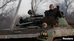 A Ukrainian serviceman waves from a tank during intense shelling on Christmas Day at the front line in Bakhmut. 