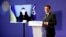 Ukrainian President Volodymyr Zelensky listens via video link as French President Emmanuel Macron delivers a speech during a French-Ukrainian conference for resilience and reconstruction in Paris on December 13.