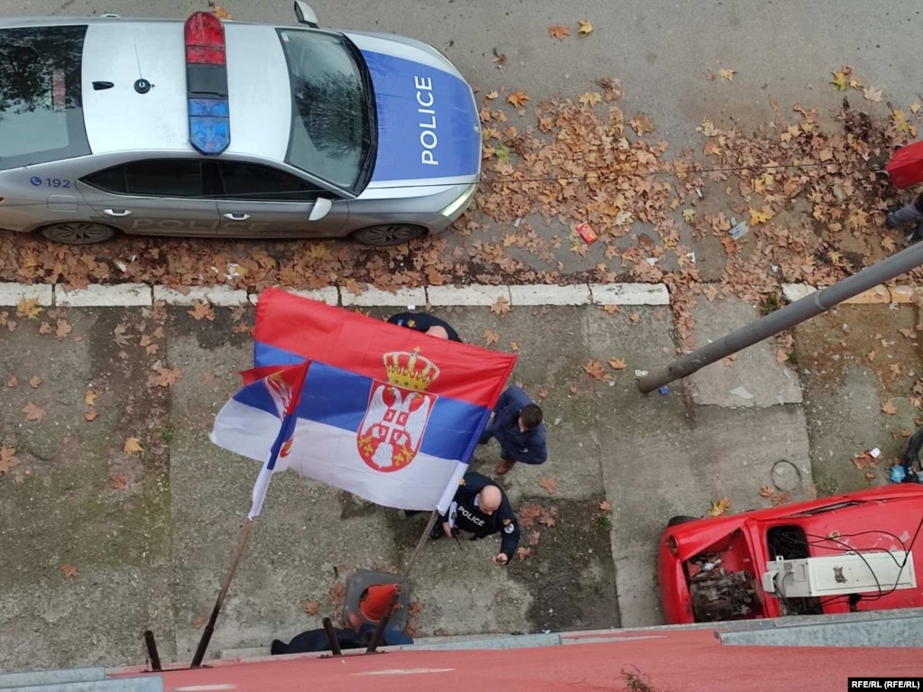 Automobil kosovske policije u Severnoj Mitrovici ispod zgrade na kojoj je okačena zastava Srbije.