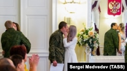 Российские молодожены во время церемонии бракосочетания в ЗАГСе