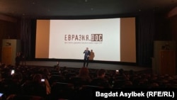 Организатор показа фильма о России обращается к зрителям в кинотеатре в Алматы. 7 декабря 2022 года
