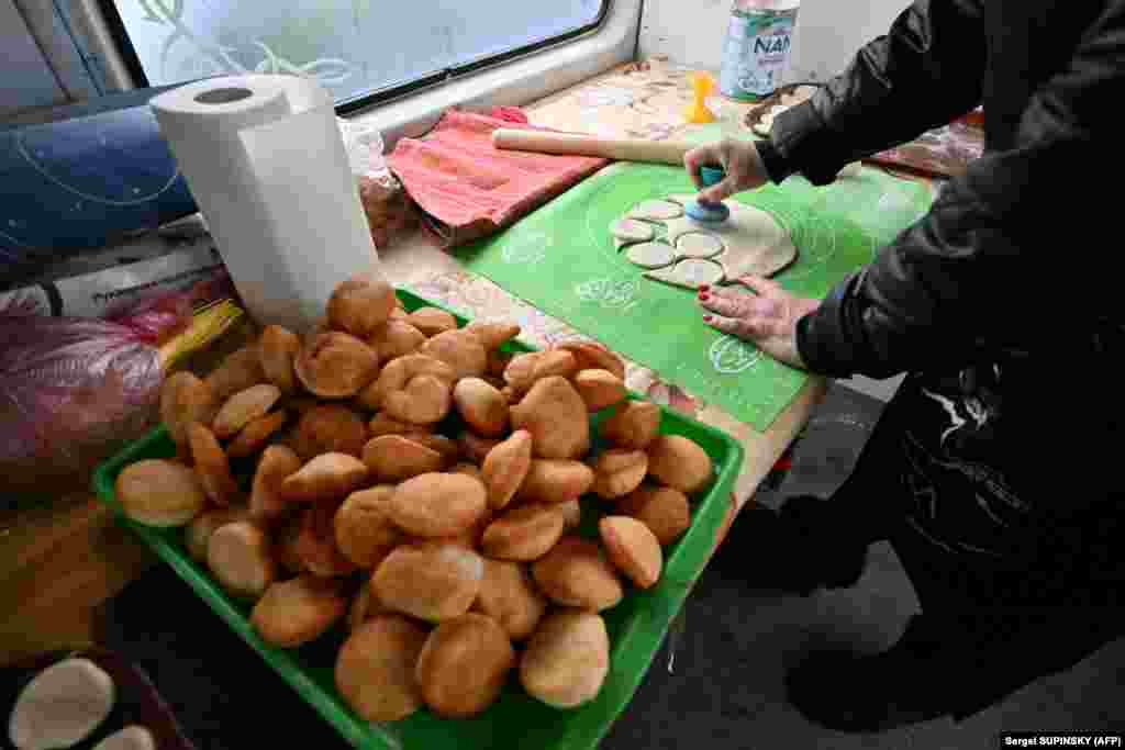 Волонтёр из Казахстана готовит тесто для баурсаков, традиционного блюда, которое предлагают гостям, подавая вместе с чаем с молоком