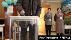 A voter submits a ballot in Kazakhstan's presidential election on November 20 in Almaty.
