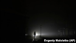 A woman walks in Kyiv amid a blackout following Russian strikes on the city. 