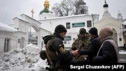 Ukraine's Security Service officers check the documents of visitors to the Kyiv Pechersk Lavra monastery on November 22 as part of a weeks-long, wide-ranging probe into suspected pro-Russia activity.