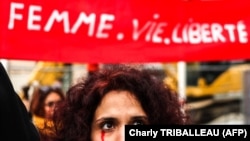 Protestatară cu lacrimi roșii pictate pe față în timpul unui miting de susținere a manifestațiilor din Iran, la Toulouse, Franța, 3 decembrie 2022