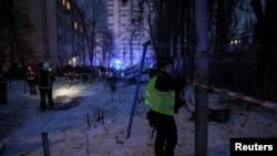 Поліцейські працюють біля будівлі, пошкодженої атакою російських безпілотників, Київ 14 грудня 2022 року
