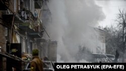 Pompierii sting incendiul izbucnit într-un bloc distrus de un bombardament în Vișhorod, în apropiere de Kiev, 23 noiembrie 2022