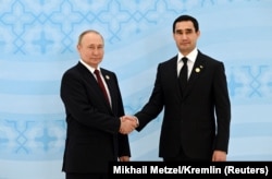 Владимир Путин (слева) пожимает руку Сердару Бердымухамедову на Каспийском саммите в Ашхабаде. Туркменистан, 29 июня 2022 года