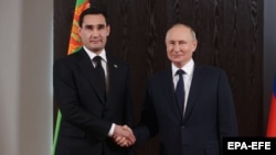 Turkmen President Serdar Berdymukhammedov (left) and Russian President Vladimir Putin shake hands during a meeting on the sidelines of the Shanghai Cooperation Organization in Samarkand, Uzbekistan, on September 15.