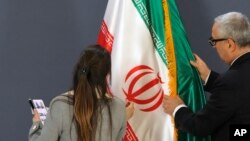 Članovi protokola namještaju iransku zastavu prije tiskovne konferencije iranskog šefa diplomacije Hosseina Amirabdollahiana i njegovog srpskog kolege Ivice Dačića, Beograd, 4. prosinca 2022.