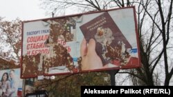 A ripped billboard promotes Russian passports in the Kherson city center.