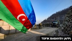 Russian peacekeepers are seen deployed at the Lachin Corridor, the Armenian-populated breakaway Nagorno-Karabakh region's only land link with Armenia, as Azerbaijani environmental activists protest what they claim is illegal mining on December 26.