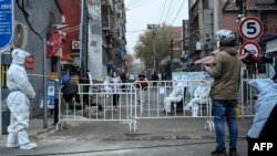 უშიშროების ძალების თანამშრომლები დამცველ აღჭურვილობაში. პეკინი, 2022 წ. ნოემბერი.