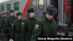 Russian conscripts called up for military service board a train as they depart for garrisons at a railway station in Omsk, Russia.