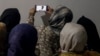 Afghan women watch the speech of the Taliban's minister for higher education, who banned women from university education in December.