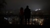 People stand amid a blackout after a Russian missile attack in Kyiv on November 23. 