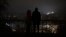 People stand amid a blackout after a Russian missile attack in Kyiv on November 23. 